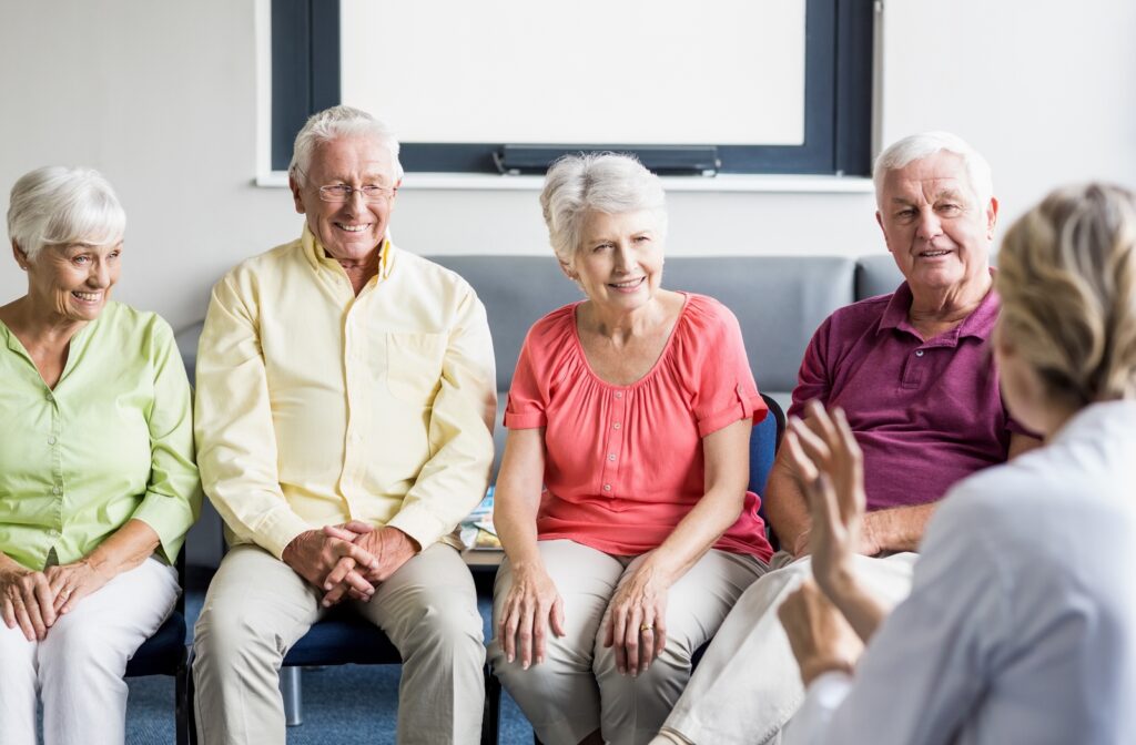 A group of five seniors seated around eachother having a discussion and being social for good health