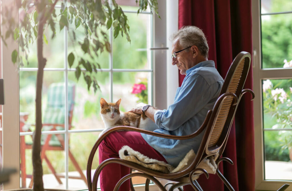 a man sits in an assisted living community with his cat
